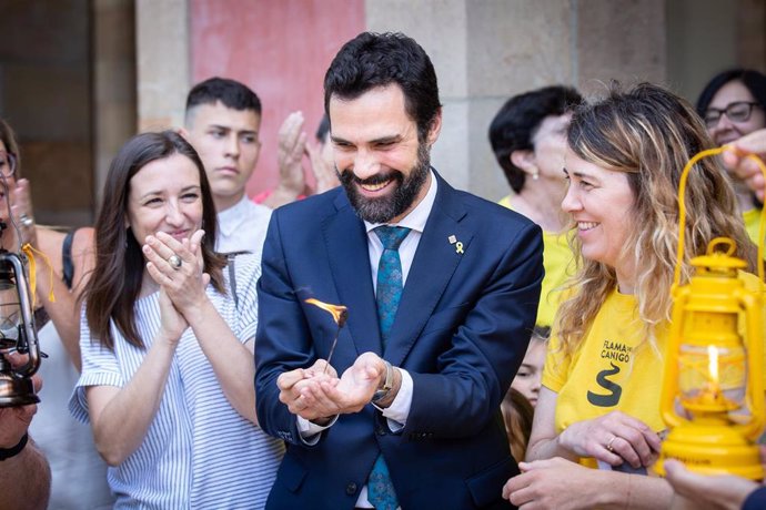 El presidente del Parlament catalán, Roger Torrent, interviene en el acto de la llegada de la Flama del Canigó a la institución. A su izquierda está la vicepresicenta de mnium Cultural, Marina Llansana, y a su derecha está Blanca de Llobet, miembro de 