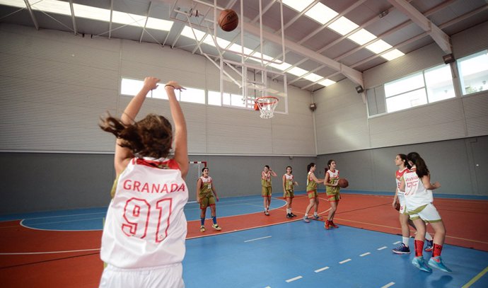 Ugadoras de un equipo juvenil de baloncesto entrenando en una cancha.