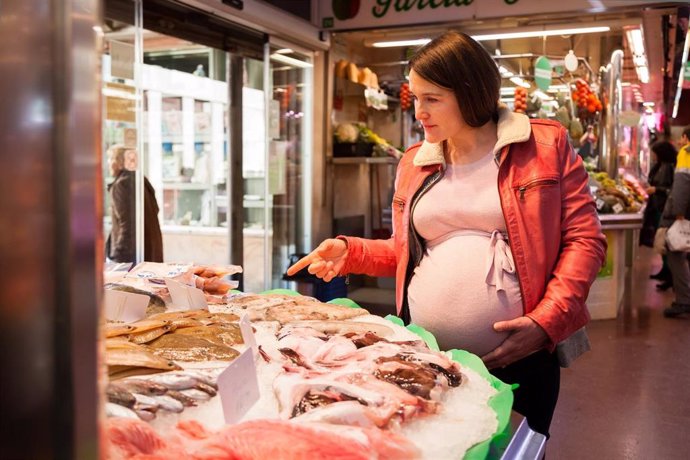 Una Jove Embarassada Comprant Peix Al Mercat.
