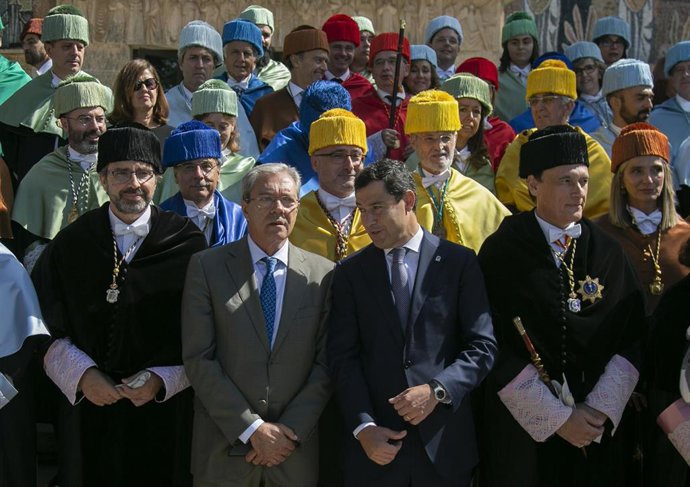 El presidente de la Junta de Andalucía, Juanma Moreno (c), intercambia unas palabras con el consejero de Economía, Rogelio Velasco (2i) durante una foto institucional realizada tras finalizar el acto. En el Campus de Rabanales.
