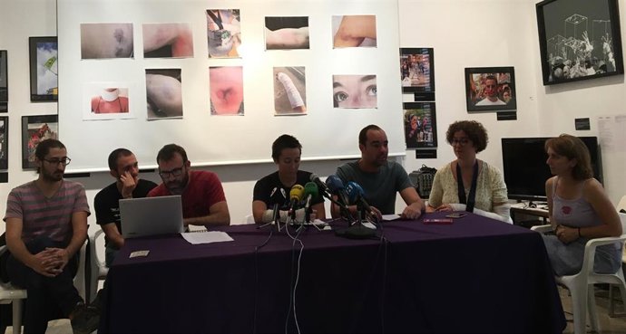 Los activistas de Forn de Barraca con fotos de las lesiones por el desalojo.