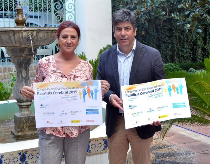 El delegado de Cohesión Social, Rafael Llamas, y la presidenta de Acpacys, con el cartel del congreso
