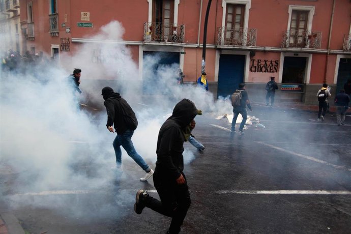03 October 2019, Ecuador, Quito: Demonstrators run away from tear gas during a protest against the increase in fuel prices and other economic measures planned by the government. Ecuadorian President Lenin Moreno had announced the day before that fuel su