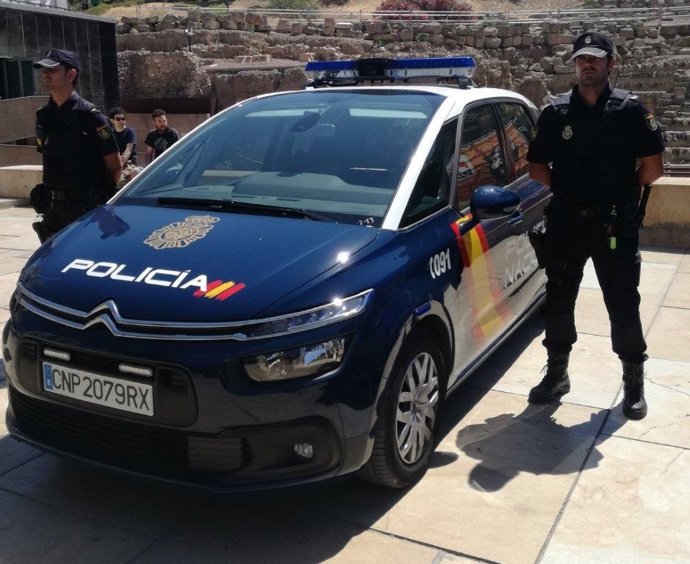 Dos agents de Policia al costat del seu cotxe.