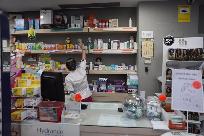 Imagen de una farmacéutica cogiendo un medicamento en una farmacia de Madrid.