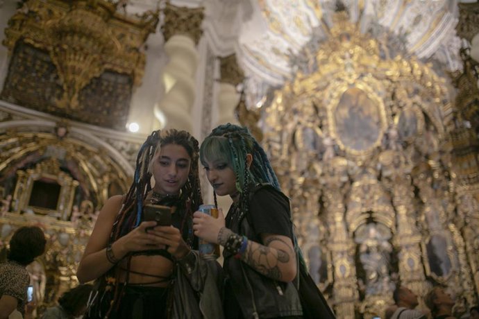La Iglesia San Luis de los Franceses abre sus puertas al público durante la 'Noche en Blanco'. Dos jóvenes usan el móvil para traducir una frase en latín, inscrita en una leyenda de la iglesia.