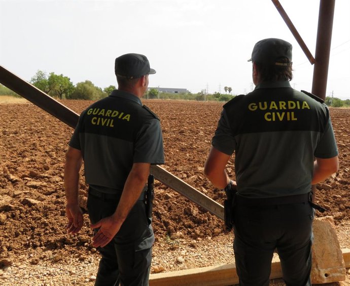 Dos agentes de la Guardia Civil en un campo