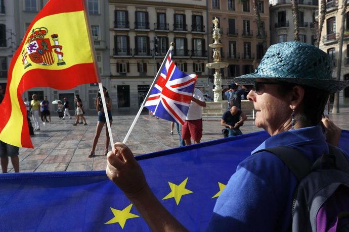 Una mujer sujeta la bandera europea junto a la española y la británica en la plaza de La Constitución de la capital malagueña, en una imagen de archivo