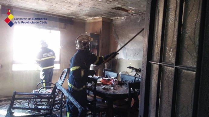 Bomberos actuando en un incendio en una casa en La Línea