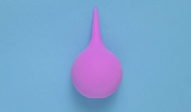 Enema on blue background, medical concept, top view, minimalism