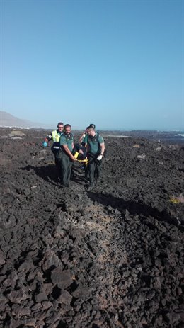 Agentes de la Guardia Civil y personal del SUC trasladan a uno de los inmigrantes heridos llegados a una cala de Haría, en Lanzarote