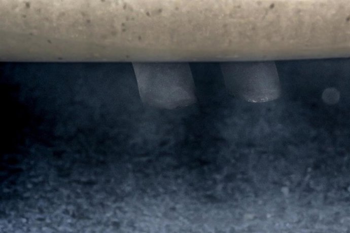 Tubo de escape de un coche emitiendo polución.