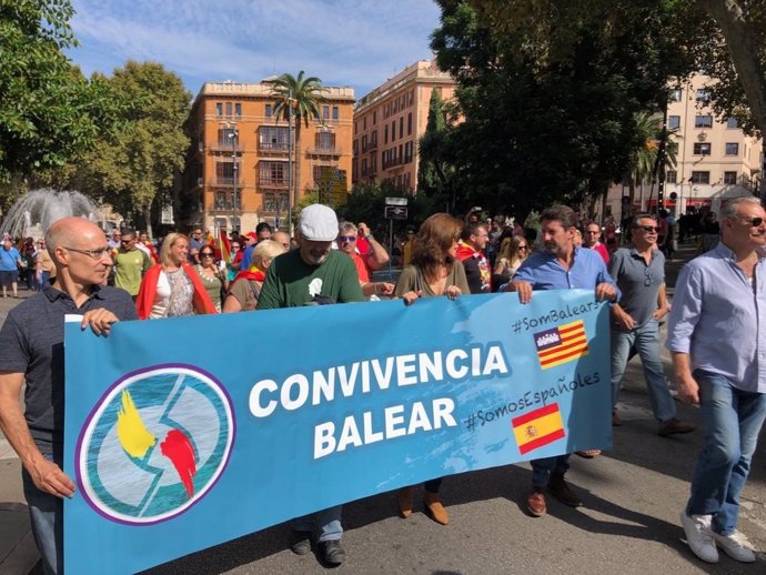 Alguns assistents a la manifestació del Dia de la Hispanitat porten un cartell de 'Convivncia Balear'.