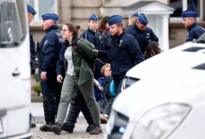 Agentes de la Policía belga detienen a una activista medioambiental durante una protesta de 'Extinction Rebellion' en Bruselas