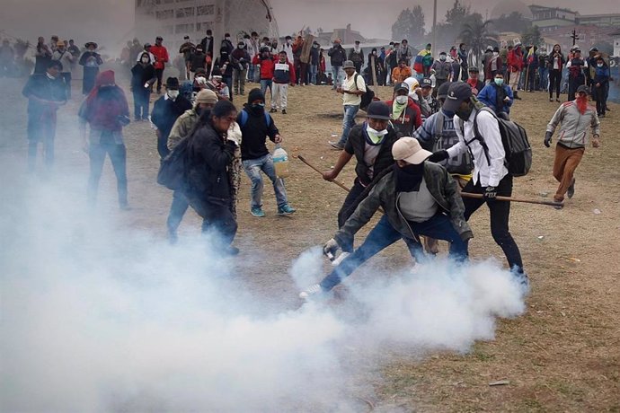 11 October 2019, Ecuador, Quito: A protestor hurls a teargas canister during clashes between Ecuadorian indigenous people and security forces. The South American country has seen nationwide protests against the government's decision to lift 40-year-old 