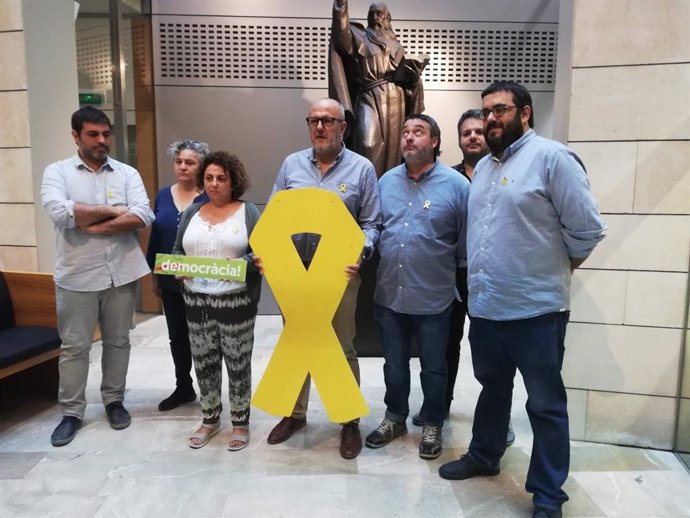 Miembros de MÉS posan con un lazo amarillo junto a la sala de prensa del Parlament después de conocerse la sentencia del 'procés'.