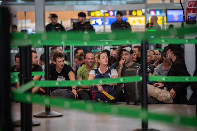 Un grupo de personas permanece sentado en el Aeropuerto de Barcelona en protesta por la sentencia del Tribunal Supremo sobre el juicio del procés.