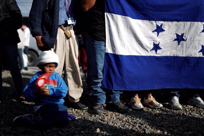 Migrantes hondureños con una bandera de su país en México