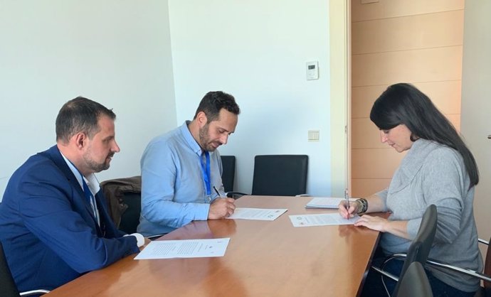 La secretaria general del grupo parlamentario de Vox en el Congreso, Macarena Olona, firma un documento de la Unión de Militares de Tropa, ante dos de sus representantes.