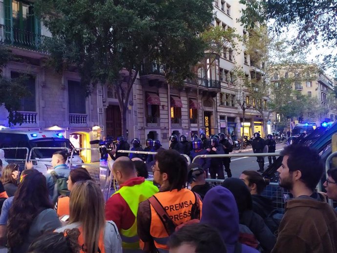 Manifestantes ante el cordón policial que rodea la Delegación del Gobierno en Catalunya.