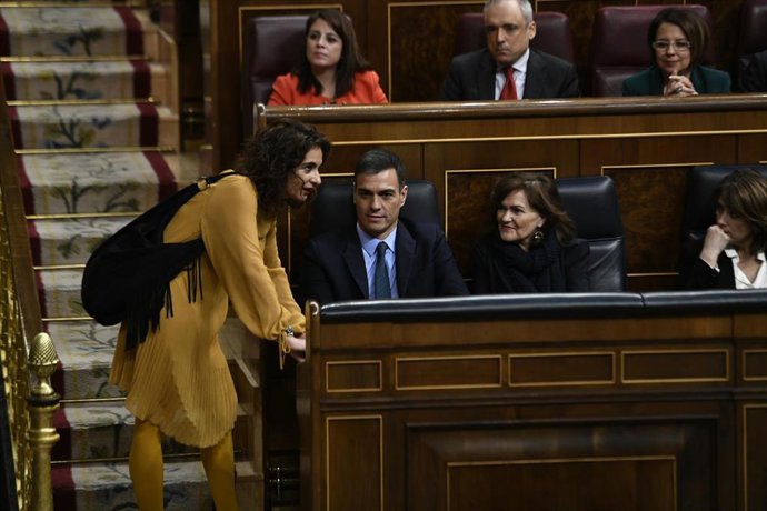 La ministra de Hacienda, María Jesús Montero, habla con el presidente y la vicepresidenta del Gobierno, Pedro Sánchez, y Carmen Calvo, tras una de sus intervenciones en la segunda jornada del debate de enmiendas a la totalidad del proyecto de Ley de Pre