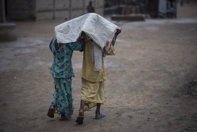 Dos personas se refugian de la lluvia en Nigeria