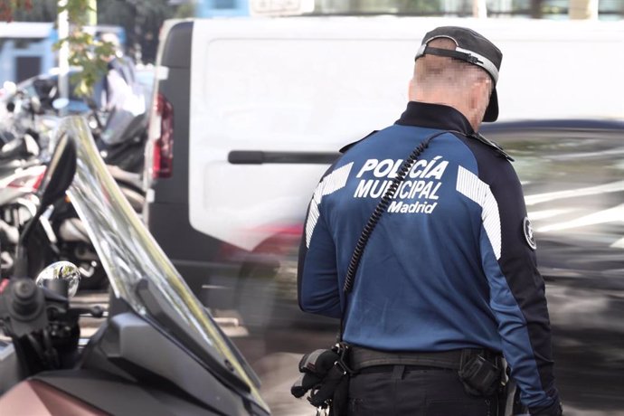 Un agente de la Policía Municipal de Madrid junto a unos vehículos en una calle de la capital, a 1 de octubre de 2019.