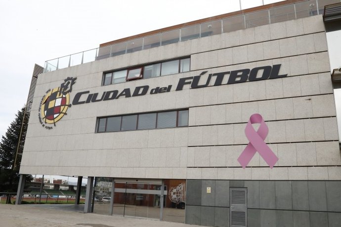 Lazo rosa en apoyo a la lucha contra el cáncer de mama en la fachada de la Ciudad del Fútbol de Las Rozas