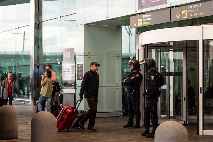 Dos agentes de la Policía Nacional fente a una de las puertas de acceso al Aeropuerto de Barcelona- El Prat.