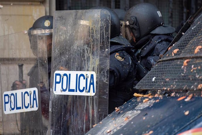 Agentes de la Policía Nacional son alcanzados por balas de pintura durante una manifestación en Barcelona en reacción a la sentencia del procés