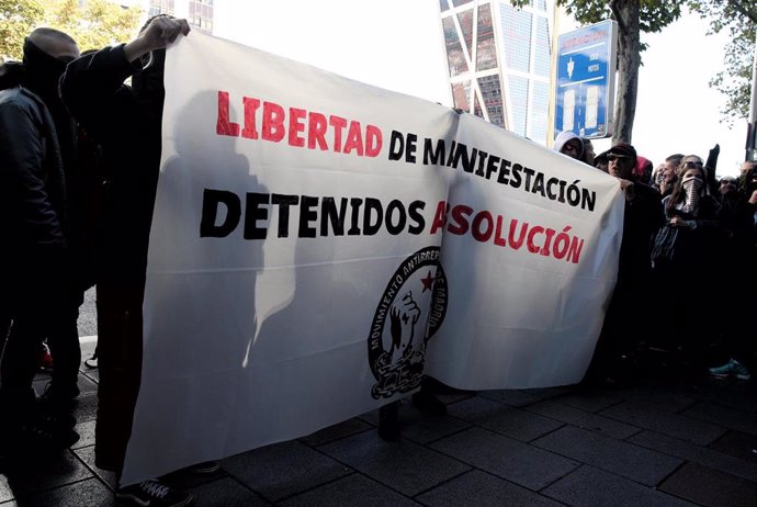 Jóvenes integrantes del Movimiento Antirrepresivo de Madrid con una pancarta en la que se lee, `Libertad de Manifestación, Detenidos Absolución se han concentrado esta mañana frente a los juzgados de guardia de Plaza de Castilla en apoyo a los detenidos 