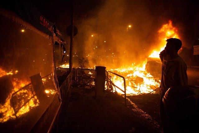 Un manifestante junto al fuego de una hoguera durante los disturbios en la Plaza de Urquinaona y la Calle Roger de Lluría, en Barcelona a 18 de octubre de 2019.