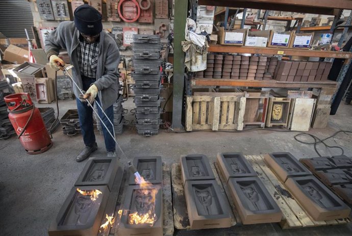 31 January 2019, England, London: A worker heats sand cast before metal is poured during the manufacture process of the masks awards of the British Academy of Film and Television Awards (BAFTA). Photo: Steve Parsons/PA Wire/dpa