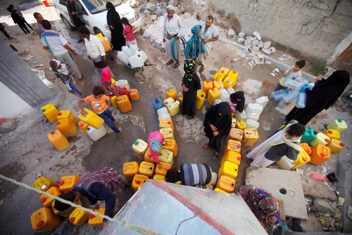 Personas esperan a recoger agua en Saná