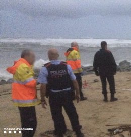 Los Mossos en la playa donde ha sido encontrado el cadáver de un hombre por el temporal
