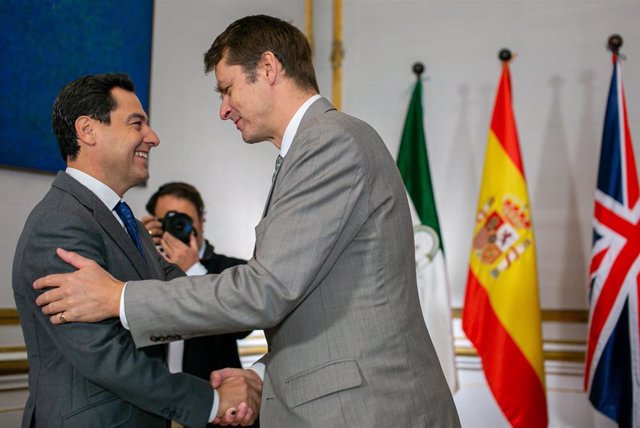 El presidente de la Junta de Andalucía, Juanma Moreno (i) saluda al Reino Unido en España, Hugh Elliot (d) al inicio de una reunión.