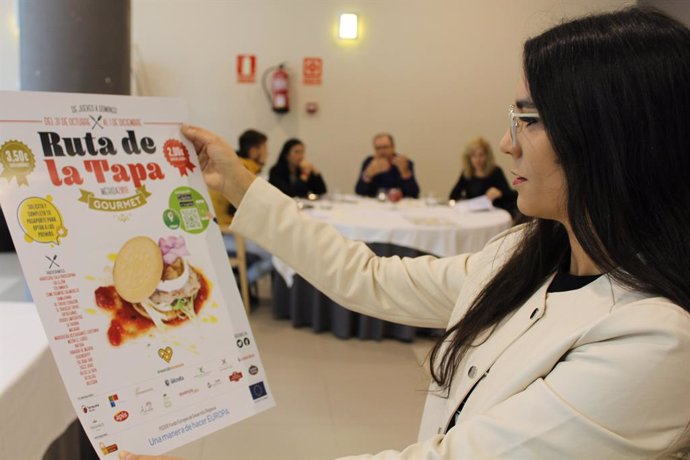 Pilar Amor con el cartel de la Ruta de la Tapa Gourmet en Mérida