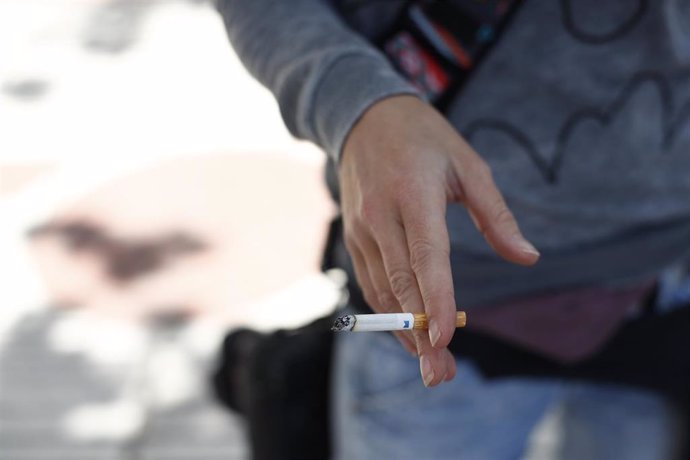 Mujer fumando un cigarro.