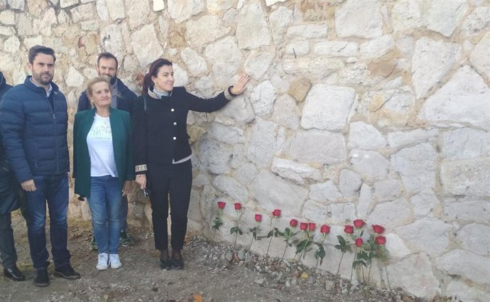Ana Sánchez en la tapia del cementerio de Zamora donde se han dejado 13 rosas en homenaje a las victimas del franquismo.