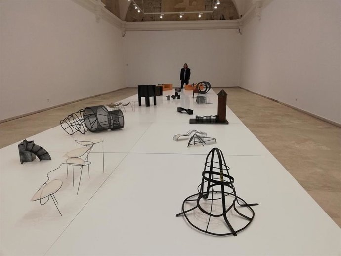 Susana Solano, al fondo de la imagen, contempla algunas de las obras de la muestra Acta (dos)