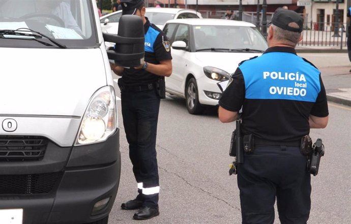 Dos agentes de la Policía Local de Oviedo realizan una inspección a una furgoneta.