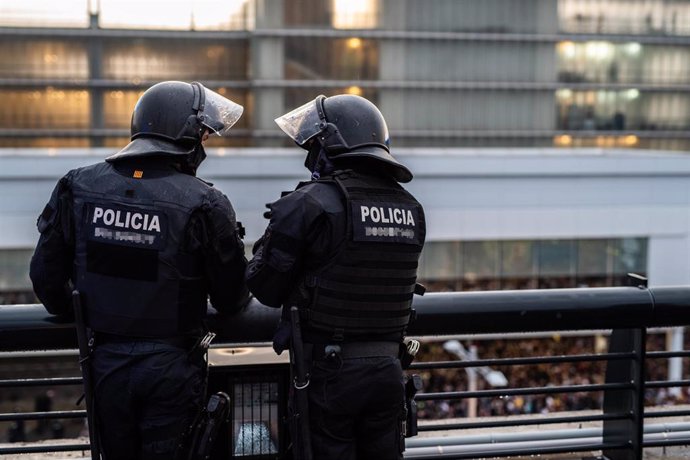 Dos agentes de los Mossos de Esquadra en el Aeropuerto de Barcelona-El Prat, donde una multitud se ha concentrado en protesta por la sentencia del Tribunal Supremo sobre el juicio del 'procés', en Barcelona (España), a 14 de octubre de 2019.
