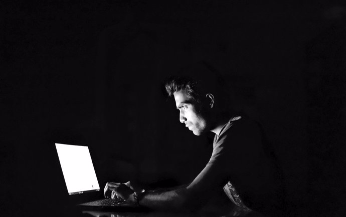 Imagen de un individuo iluminado por la pantalla del ordenador