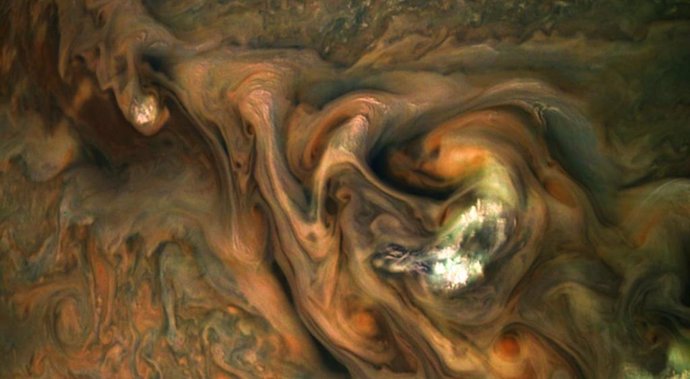 Nubes emergen en primer plano sobre la atmósfera de Júpiter