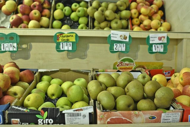 Cajas de manzanas de diferentes tipos en un mercado.
