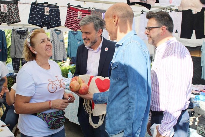 El número uno del PSOE Ignacio López con otros dirigentes socialistas dialogan con una ciudadana en un mercadillo en Málaga