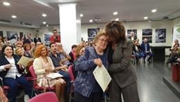 Delgado abraza a una de las familiares que han recibido el acta de reparación