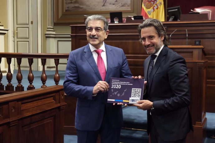 El consejero de Hacienda del Gobierno de Canarias, Román Rodríguez, entrega el proyecto de ley de presupuestos al presidente del Parlamento, Gustavo Matos