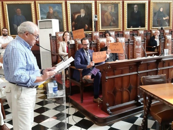 Los regidores de Cort en el Ayuntamiento muestran carteles reivindicativos en el pleno.