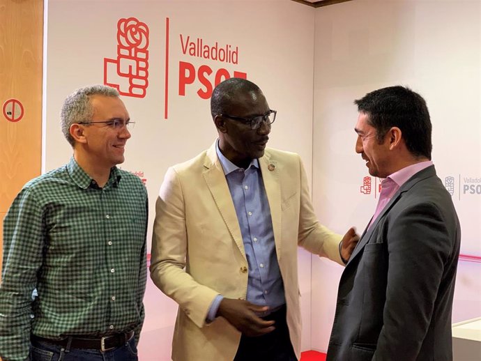 El cabeza de la lista del PSOE al Congreso por Valladolid, Javier Izquierdo, y el número cinco de la misma, José Luis Garrido, charlan con el responsabe de Política de Refugiados, Luc André Diouf.
